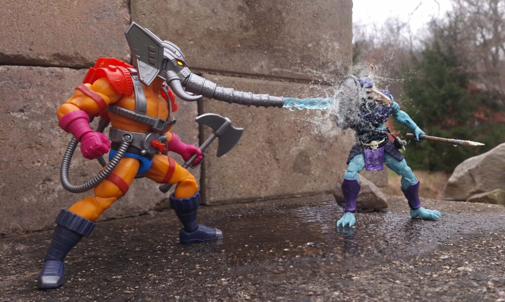 Snout Spout short story scene recreated in toy photography, with Snout Spout blasting a Skelcon toward the edge of a narrow Eternian cliff.